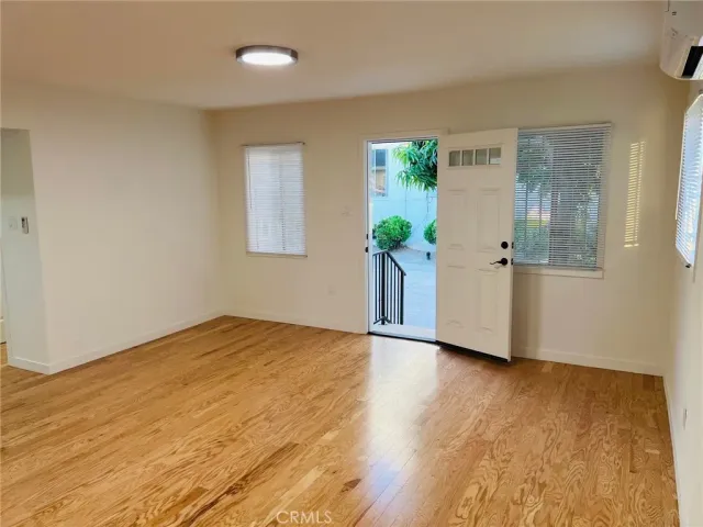a view of an empty room with potted plant and wooden floor