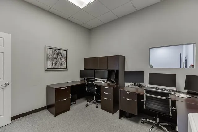 a view of a workspace with furniture and a window
