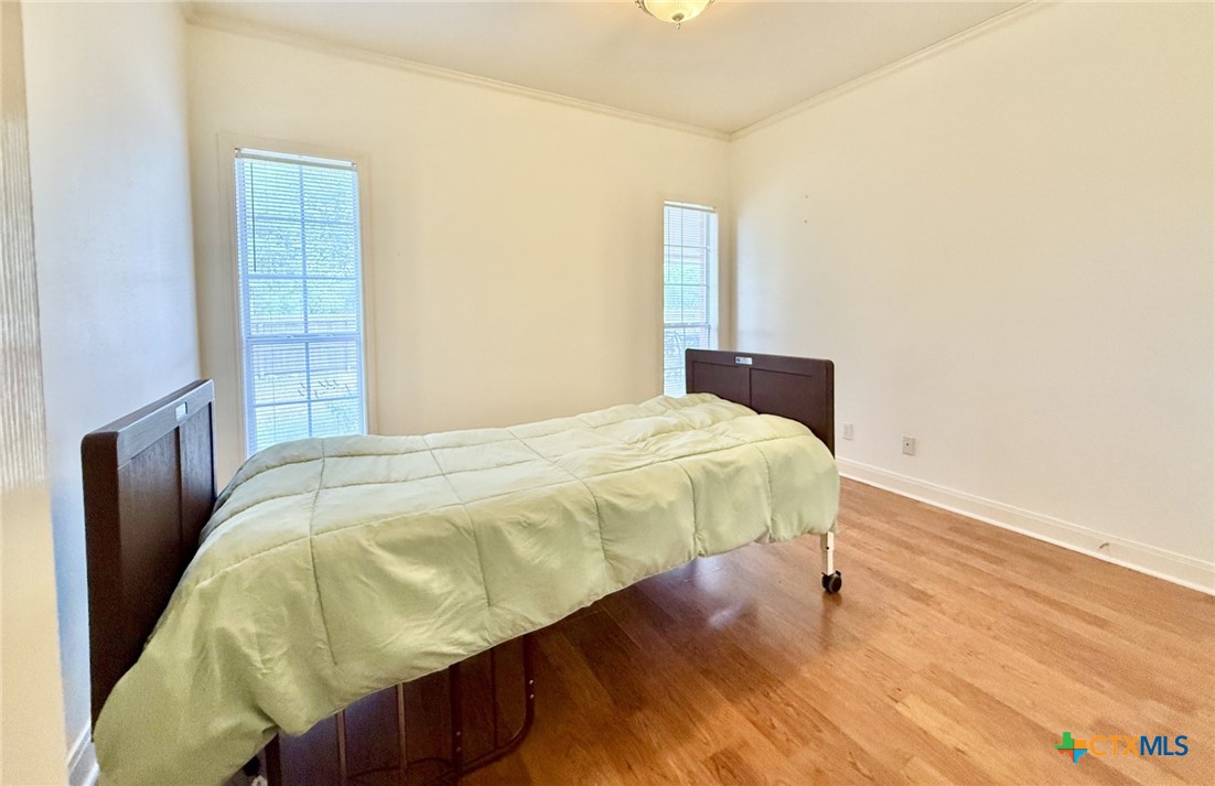415 South Trinity Street Edna, TX 77957 - Photo 36 of 46 a bedroom with a bed and wooden floor
