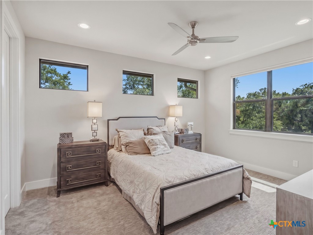 5913 Verden Ridge New Braunfels, TX 78132 - Photo 21 of 48 a bedroom with a bed a couch and a window