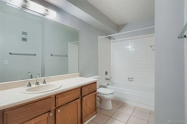 a bathroom with a granite countertop sink a toilet and shower