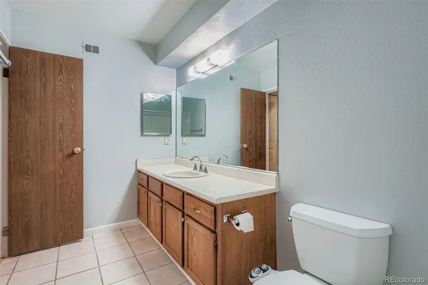 a bathroom with a sink a toilet and mirror