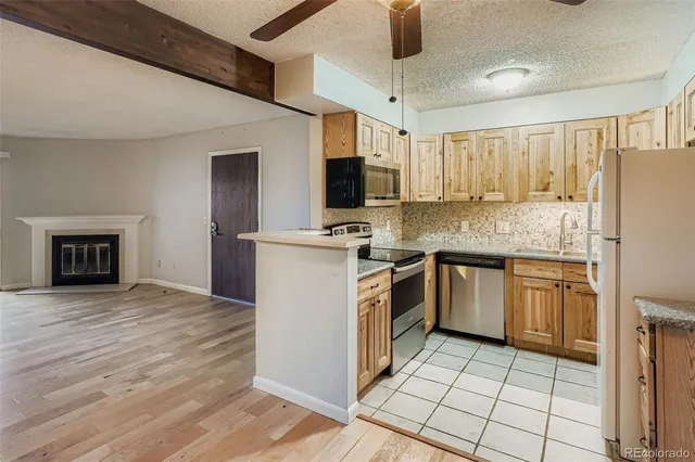 a kitchen with stainless steel appliances granite countertop a stove top oven a sink and a refrigerator