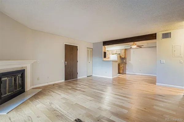a view of empty room with wooden floor and fireplace