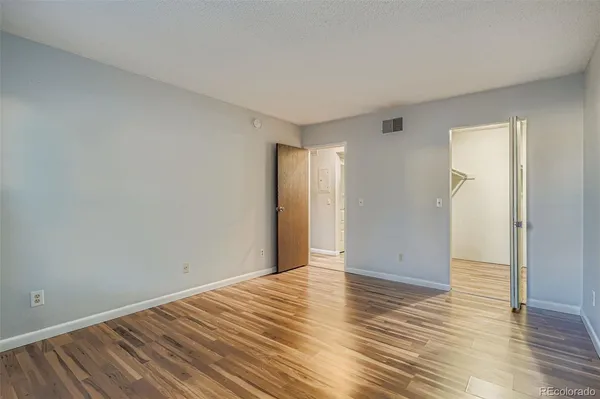 a view of an empty room with wooden floor