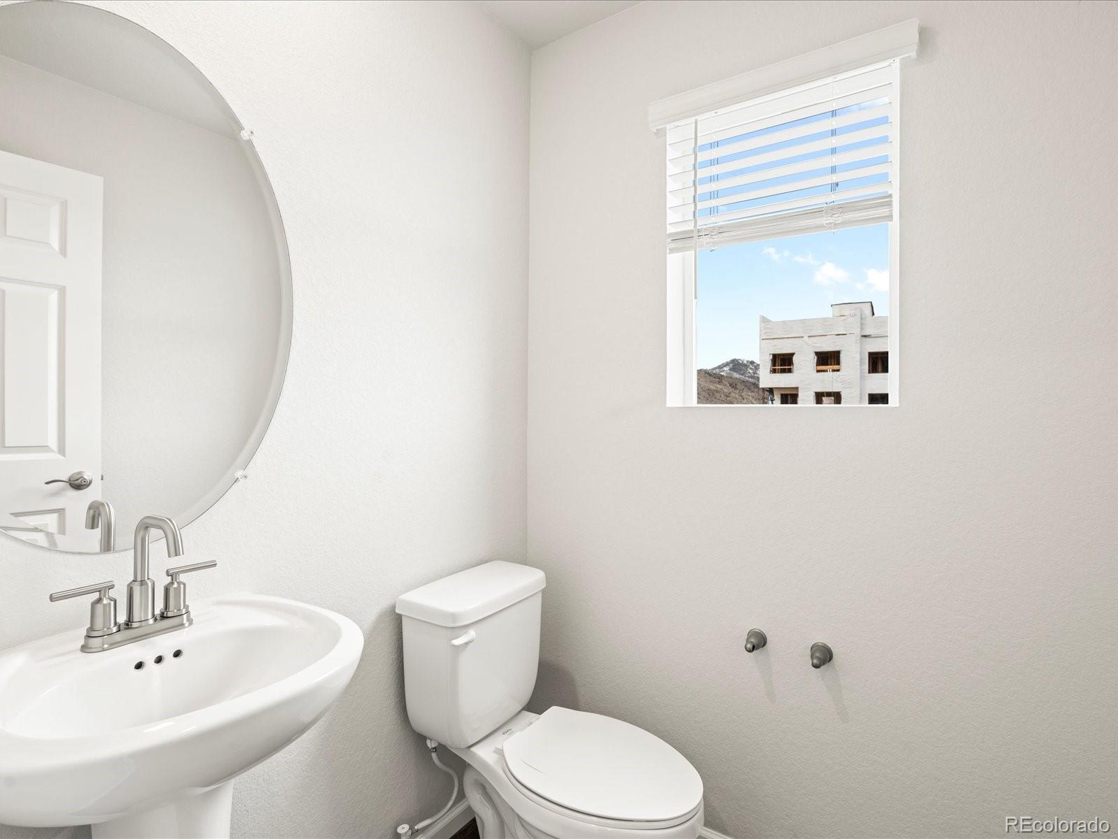 14422 Pansy Loop Morrison, CO 80465 - Photo 13 of 33 a white toilet sitting next to a bathroom sink