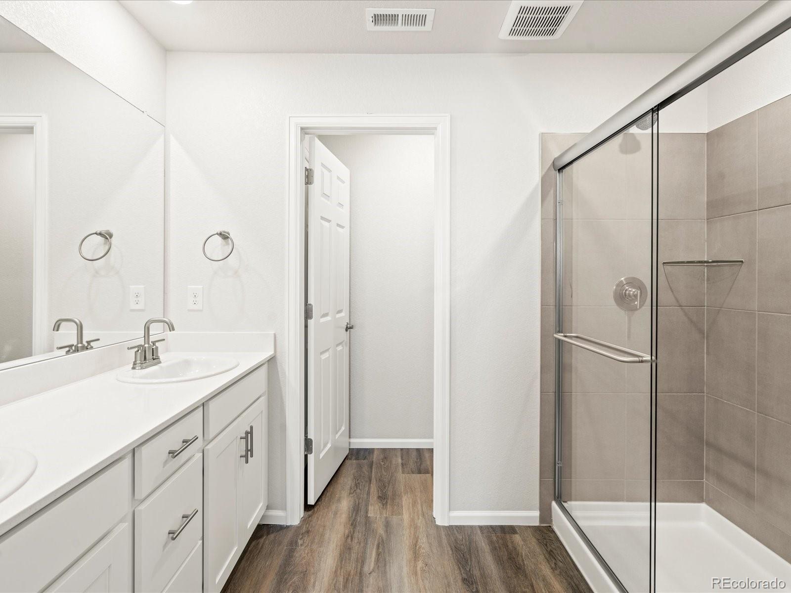 14422 Pansy Loop Morrison, CO 80465 - Photo 23 of 33 a bathroom with a double vanity sink a mirror and a shower