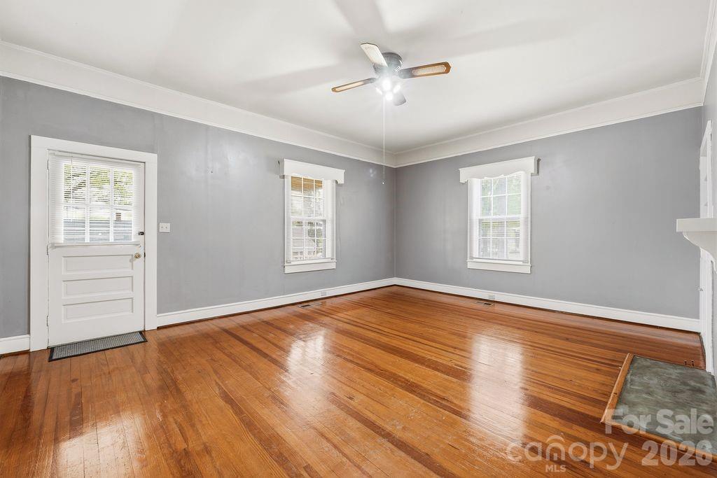 625 North Main Street Kannapolis, NC 28081 - Photo 11 of 26 an empty room with wooden floor chandelier fan and windows