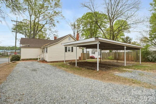 a backyard of a house with large trees and a tree