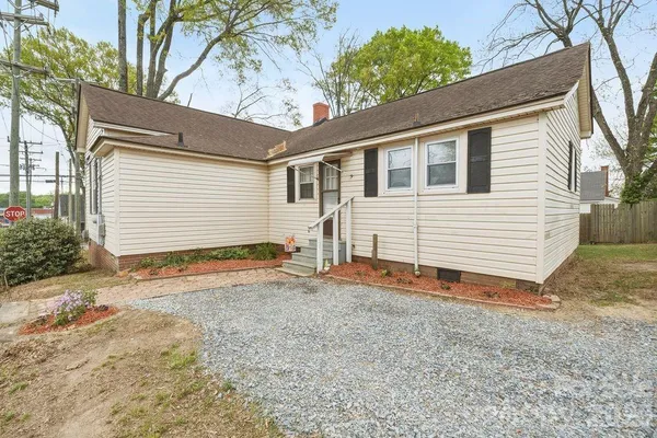 a backyard of a house with plants and wooden fence