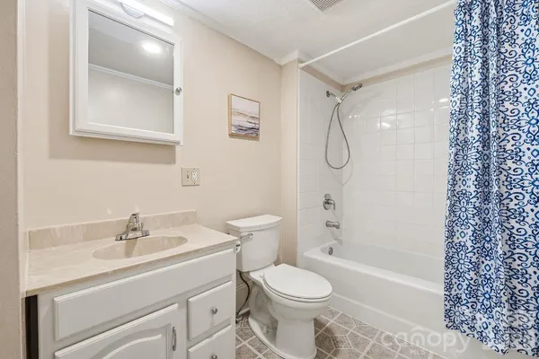 an empty room with wooden floor chandelier fan and windows