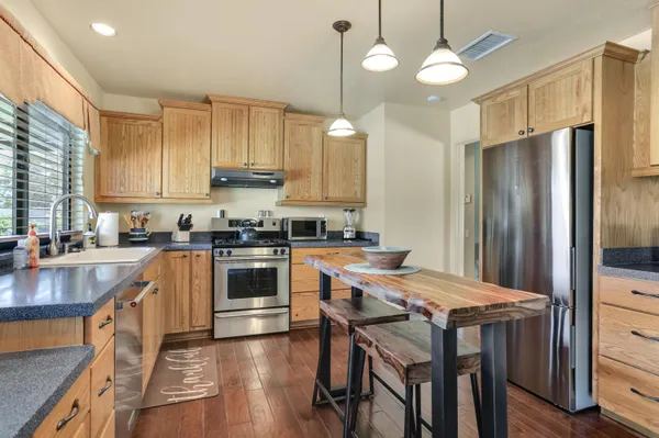 a kitchen with stainless steel appliances granite countertop a stove refrigerator sink and cabinets