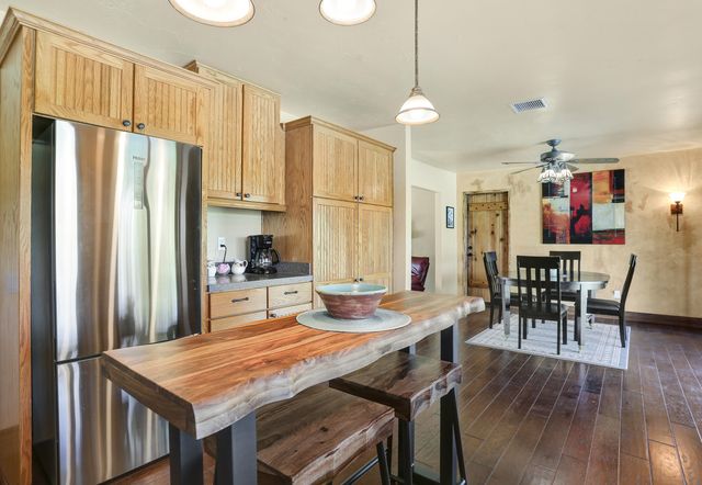 a kitchen with stainless steel appliances granite countertop table chairs and refrigerator