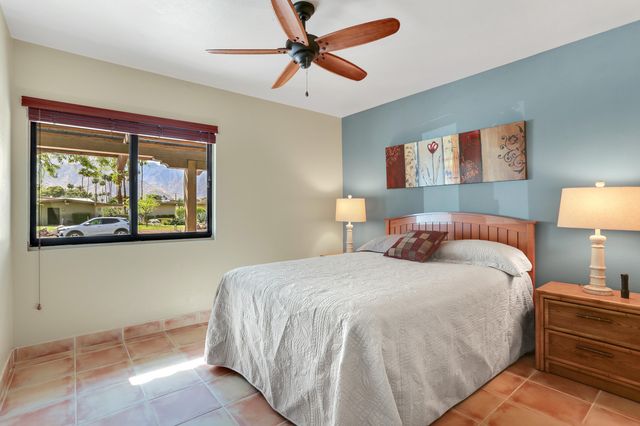 a bedroom with a bed and a painting on the wall