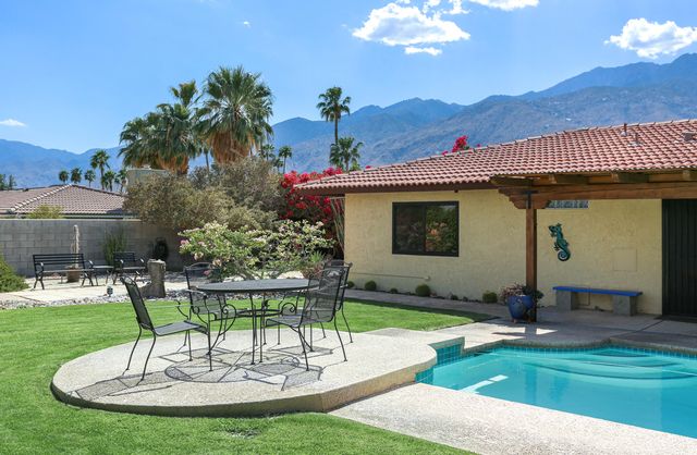 a swimming pool with outdoor seating and yard