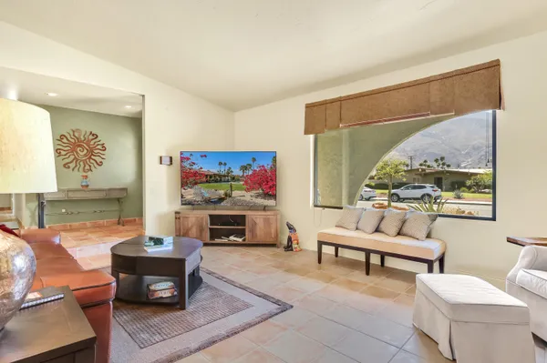 a living room with furniture a rug and a large window