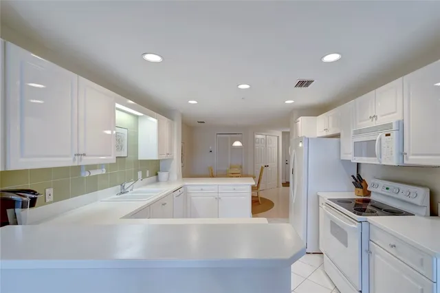 a large white kitchen with a large window