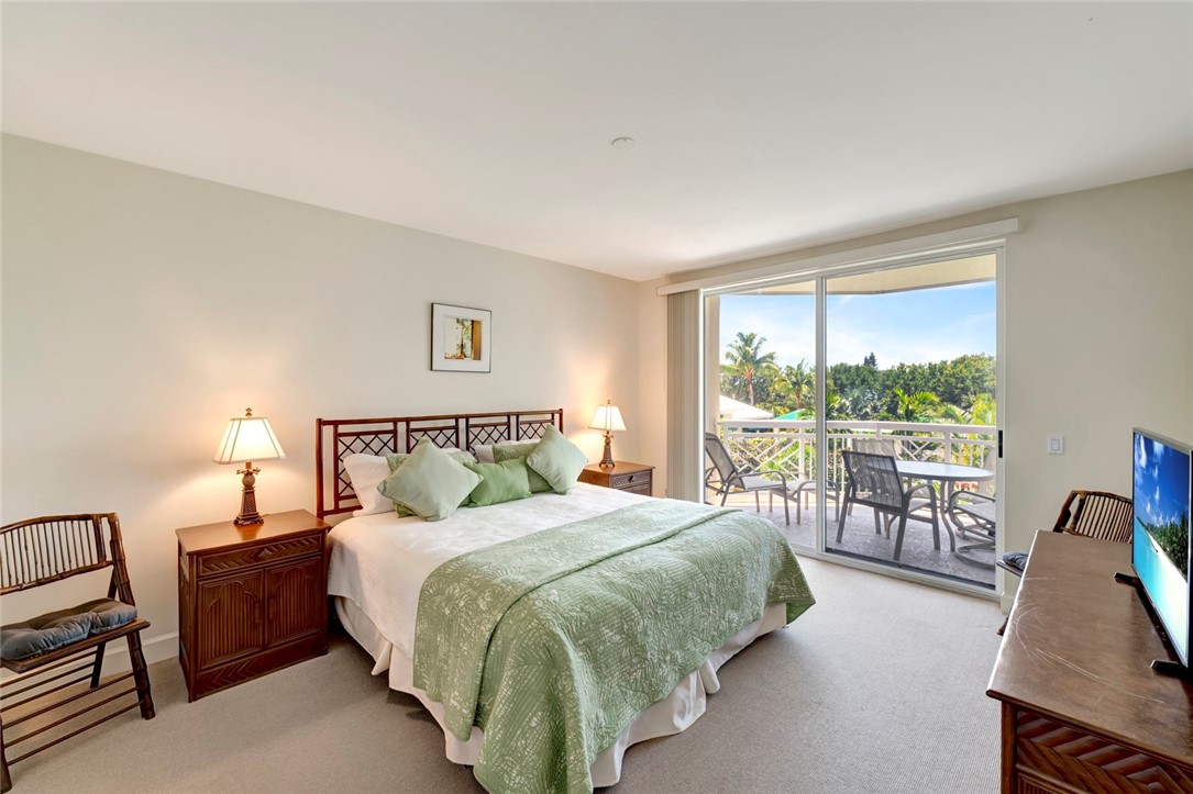 940 Turtle Cove Lane, Unit 208 Vero Beach, FL 32963 - Photo 18 of 35 a bed sitting in a bedroom next to a large window