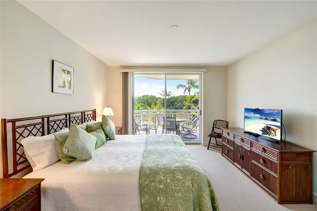 a bedroom with a bed and a flat tv screen on dresser