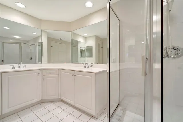 a spacious bathroom with a shower a sink and a mirror