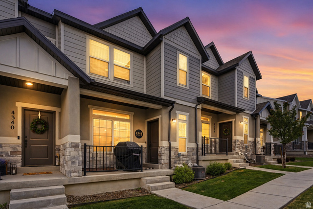 4344 Bromwell Court Lehi, UT 84048 - Photo 1 of 1 Craftsman-style home with stone siding and a porch. AI enhanced twilight photo.