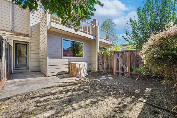 a view of a house with a yard and wooden fence
