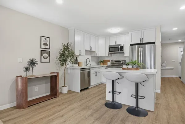 a kitchen with white cabinets and stainless steel appliances
