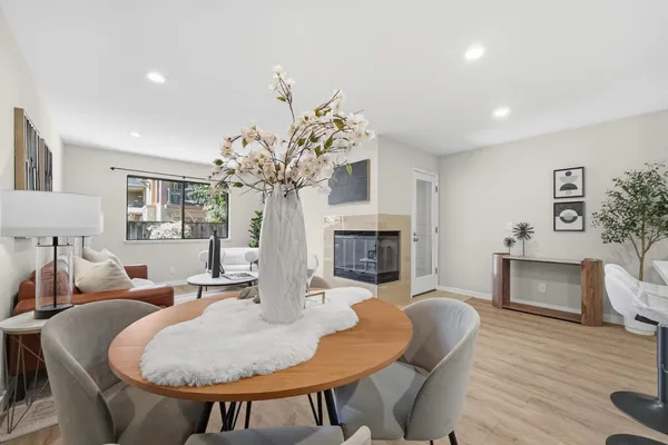 a living room with furniture a fireplace and a potted plant
