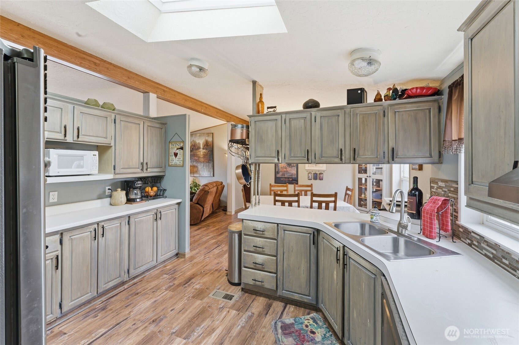 905 Cowl Street Milton Freewater, OR 97862 - Photo 26 of 32 a kitchen filled with white cabinets a sink dishwasher and a stove with wooden floor