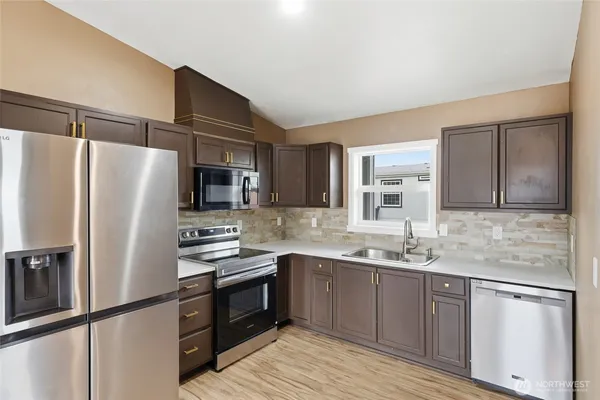 a kitchen with stainless steel appliances a refrigerator sink and microwave
