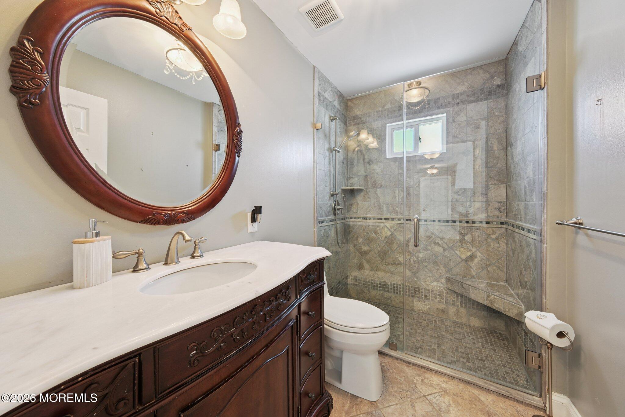8 Patton Court Manalapan, NJ 07726 - Photo 14 of 23 a bathroom with a sink a toilet and a mirror