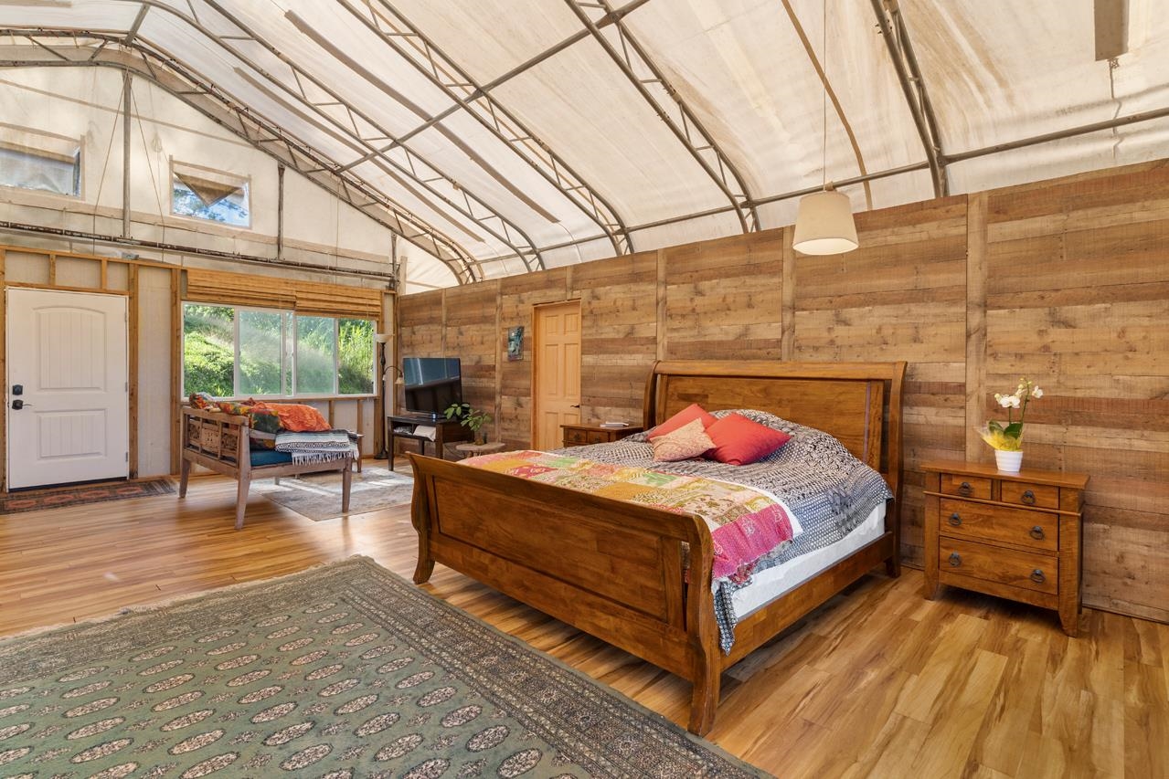676 Kaupakalua Road, Unit A Haiku, HI 96708 - Photo 14 of 21 a bedroom with a bed and wooden floor