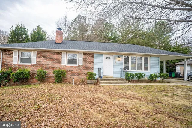 front view of house with a yard and potted plants