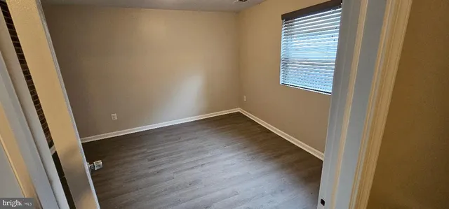 a view of a small space with wooden floor and a window
