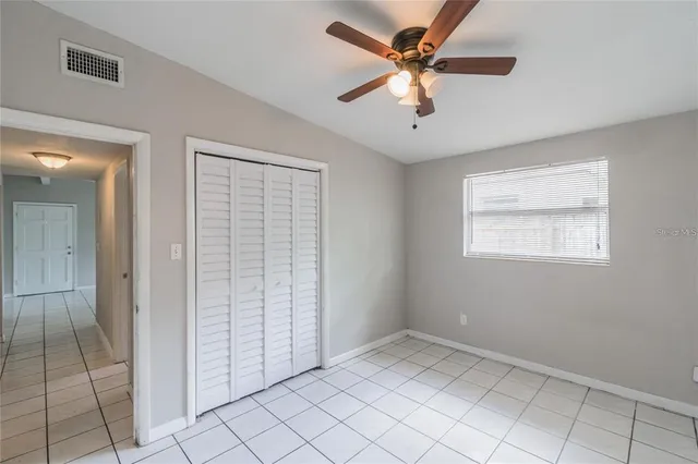 an empty room with fan and windows
