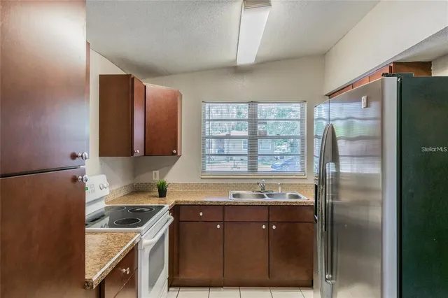a kitchen with stainless steel appliances granite countertop a refrigerator and a stove