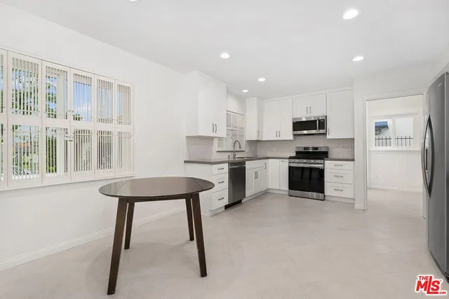 a kitchen with white cabinets and stainless steel appliances