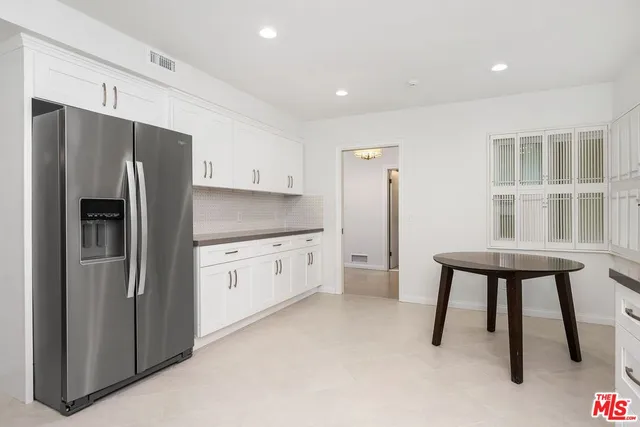a kitchen with stainless steel appliances a refrigerator sink and cabinets