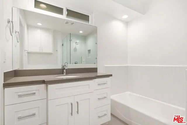 a bathroom with a granite countertop sink mirror and toilet