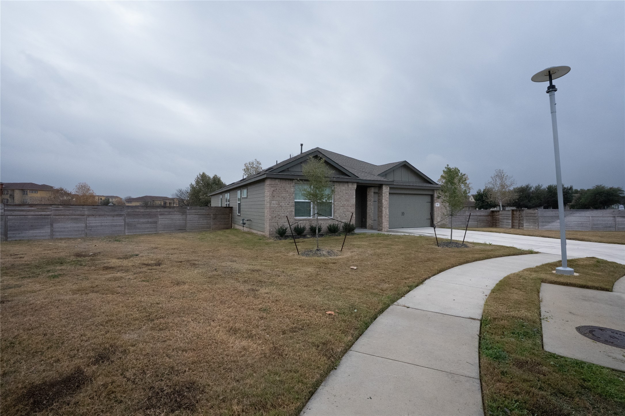 105 Carmello Kyle, TX 78640 - Photo 1 of 30 View of front of house featuring a garage, driveway, and brick siding