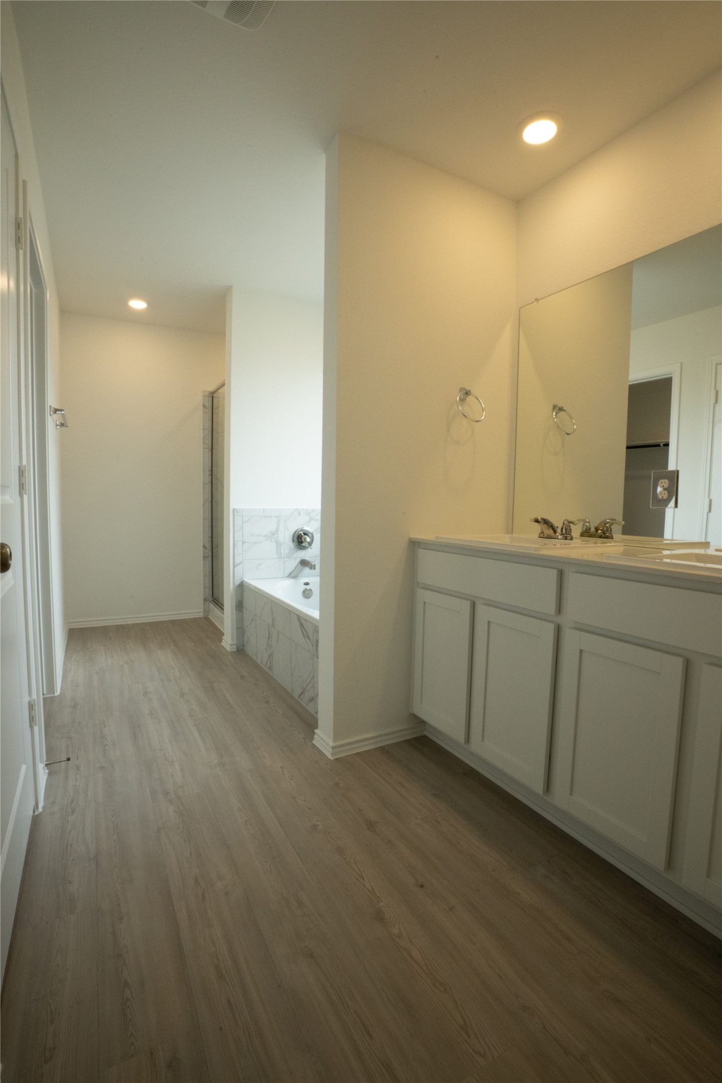 105 Carmello Kyle, TX 78640 - Photo 9 of 30 Bathroom featuring a marble finish shower, dark wood-type flooring, vanity, a bath, and recessed lighting