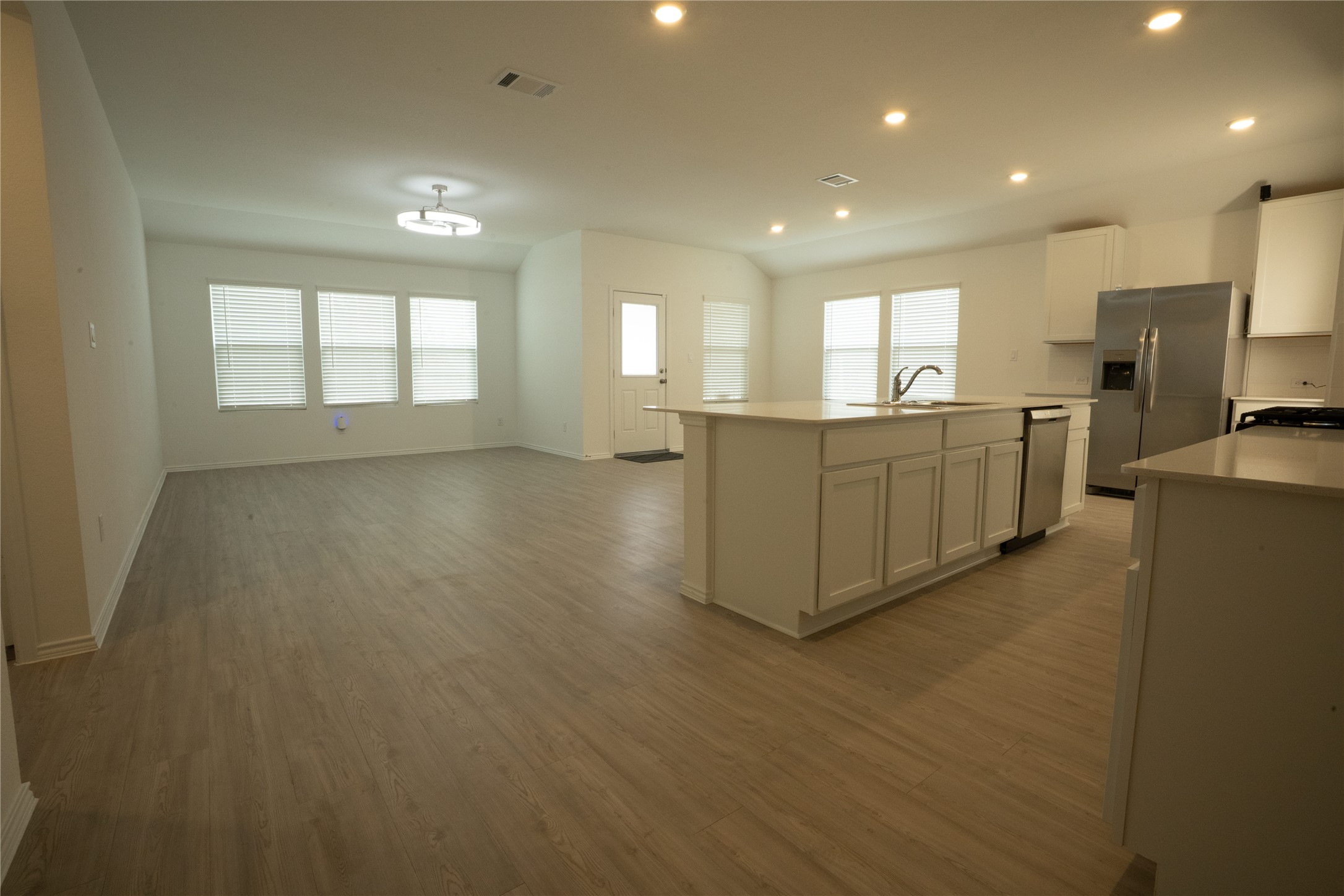 105 Carmello Kyle, TX 78640 - Photo 28 of 30 Kitchen with stainless steel appliances, recessed lighting, a center island with sink, light wood-type flooring, and open floor plan