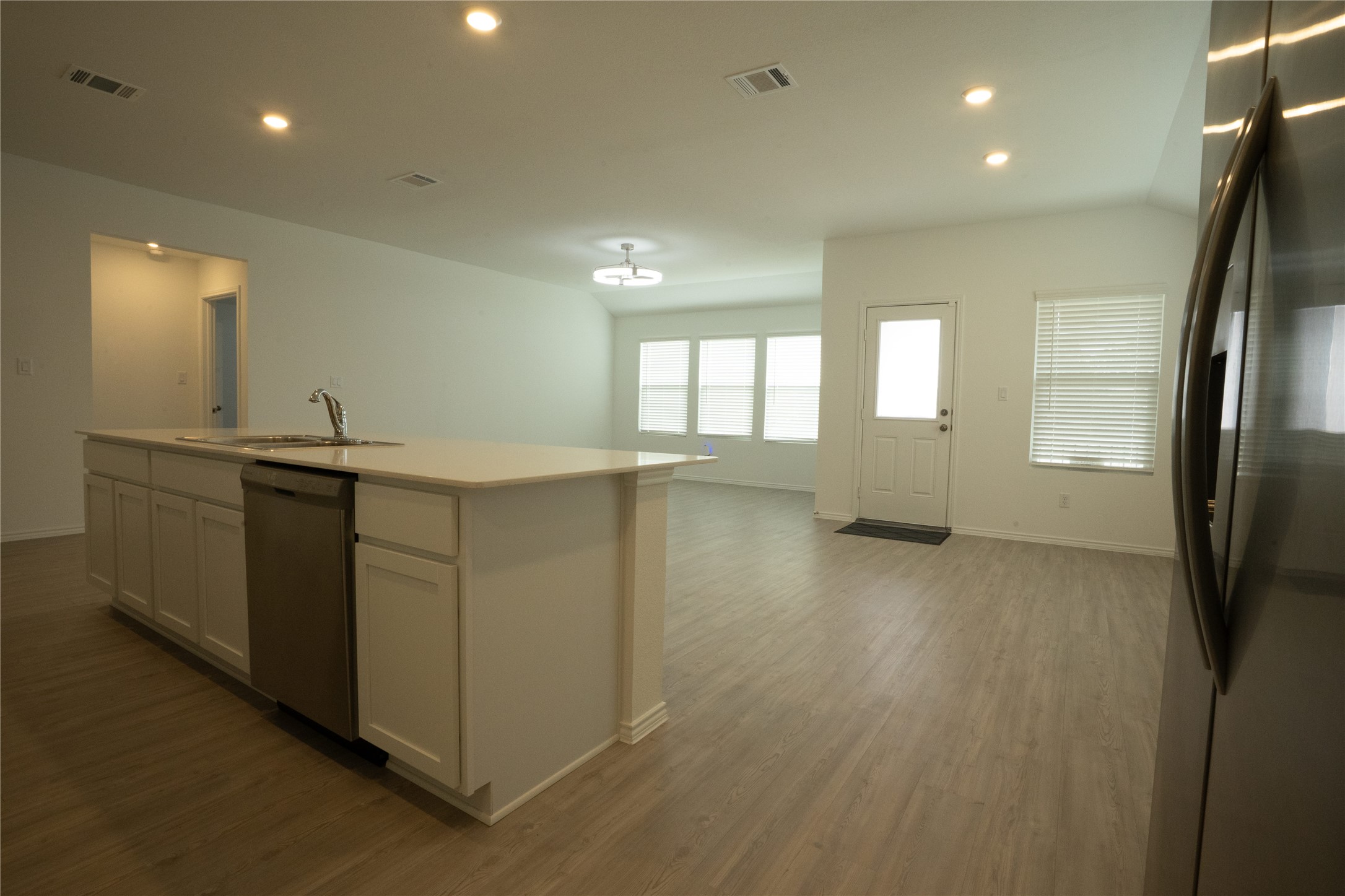 105 Carmello Kyle, TX 78640 - Photo 30 of 30 Kitchen with stainless steel appliances, recessed lighting, open floor plan, white cabinets, and dark wood-type flooring