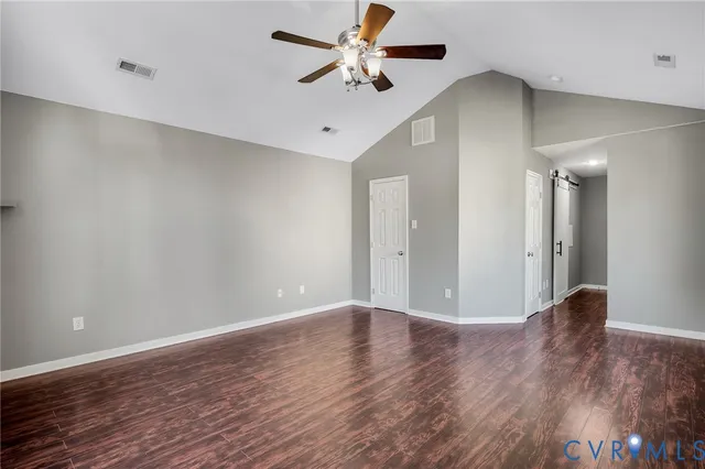 a view of an empty room with wooden floor