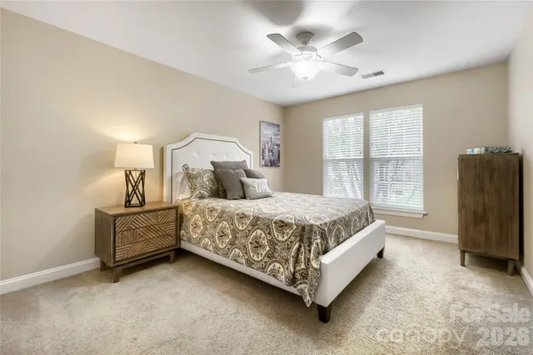 a spacious bedroom with a bed and a chandelier