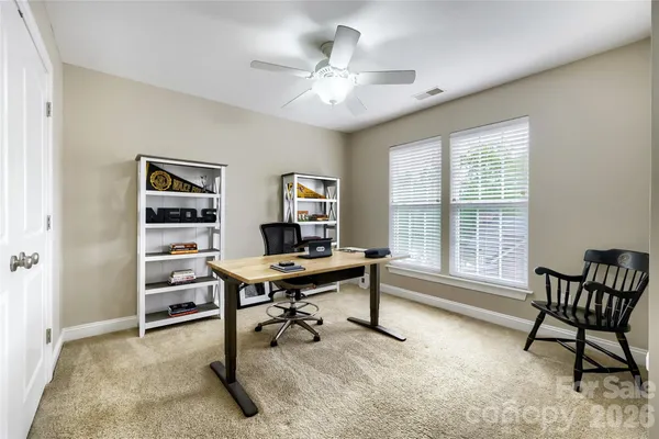 a view of a workspace with furniture and a window