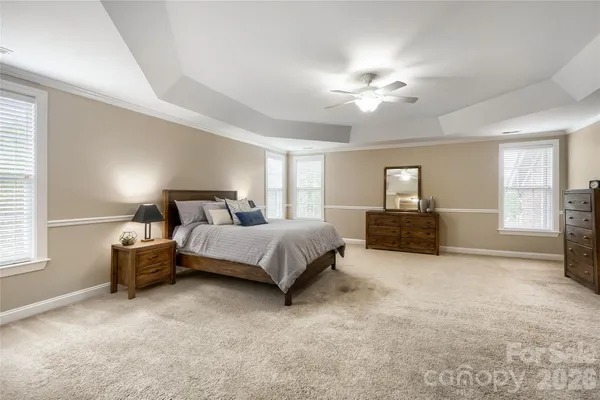 a spacious bedroom with a bed and a chandelier