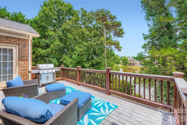 a balcony with wooden floor and outdoor seating