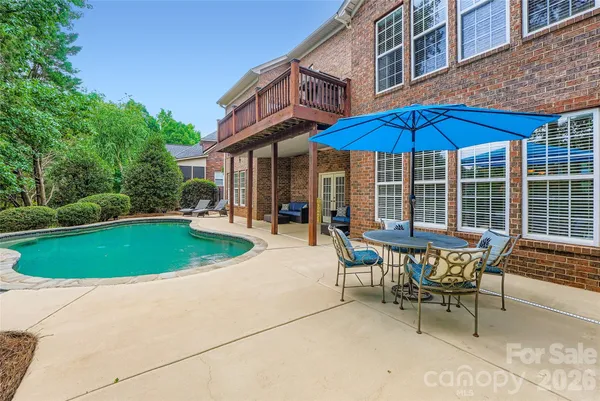 a patio with a table and chairs under an umbrella