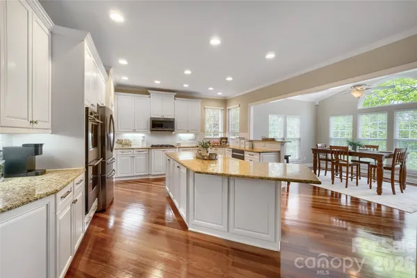 a large kitchen with stainless steel appliances granite countertop a large center island and a sink